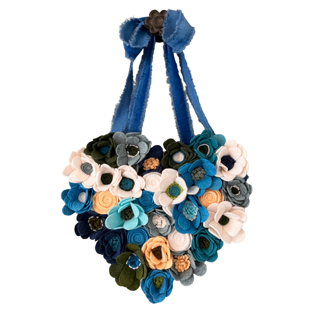 Heart-shaped decorative hanging with multicolored flowers on a white background