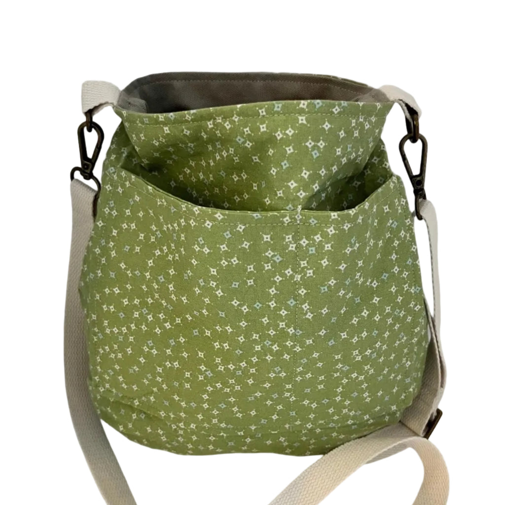 Green patterned bag with a beige strap on a white background