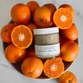 Clementine sugar scrub in a bowl with clementines on a marble surface