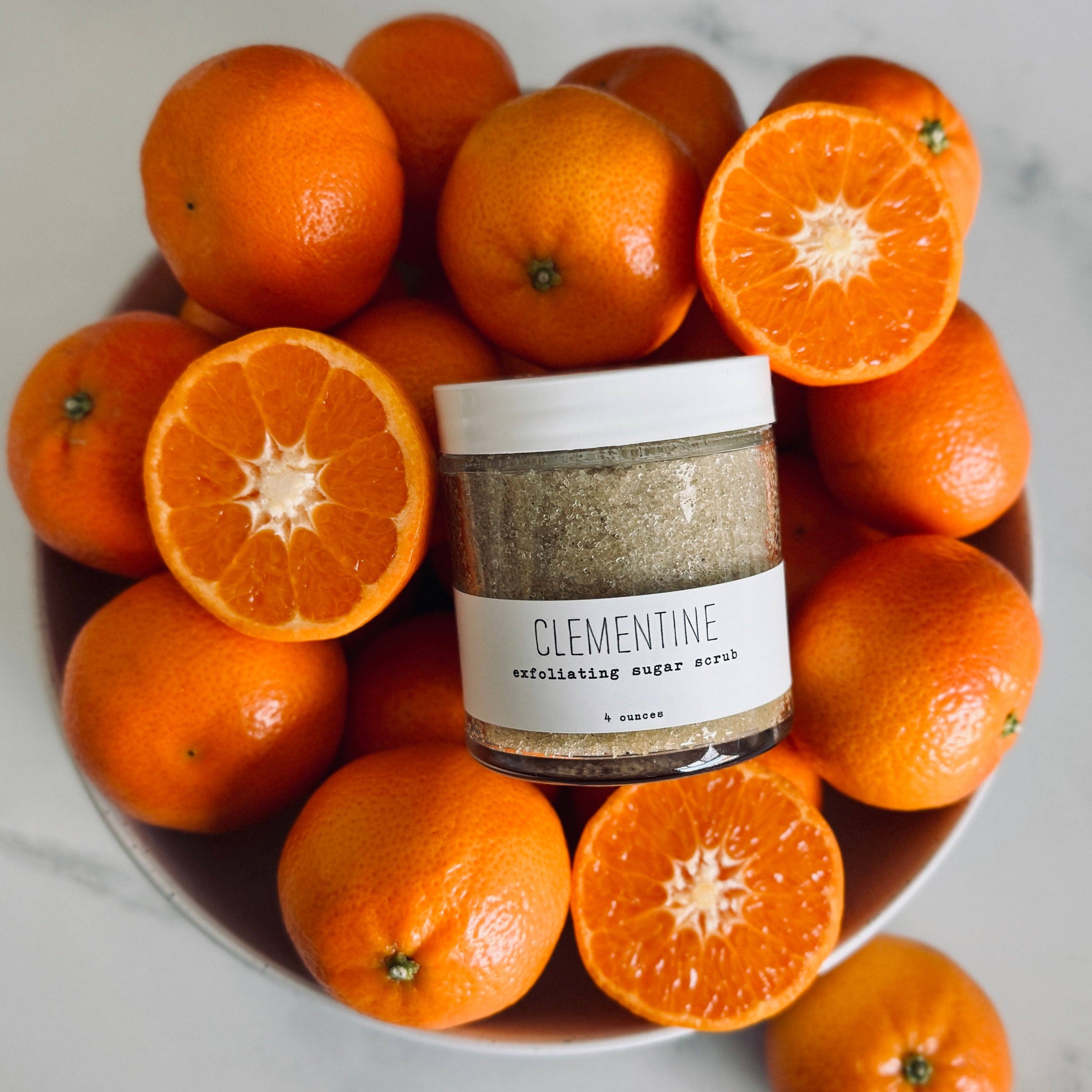 Clementine sugar scrub in a bowl with clementines on a marble surface