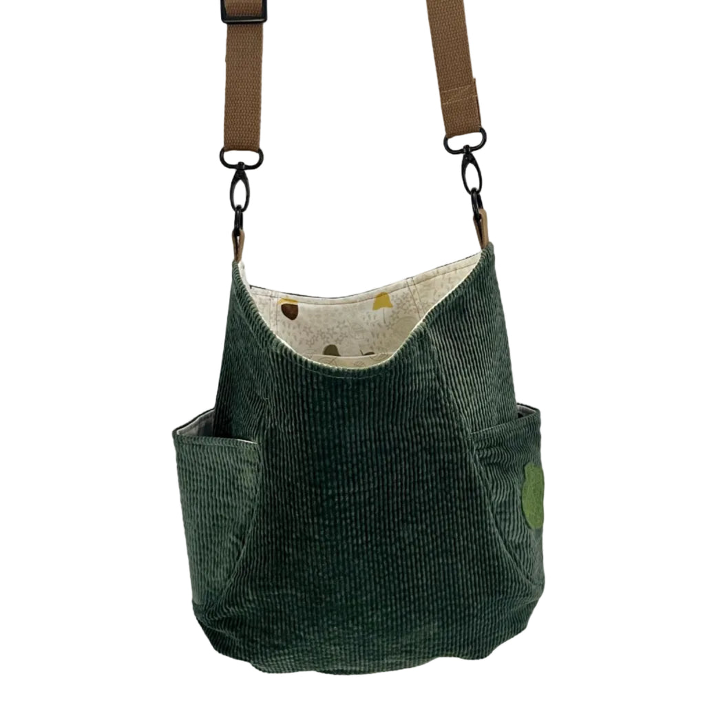 Green corduroy bag with a strap on a white background