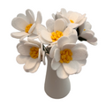 White flowers with yellow centers in a vase on a white background