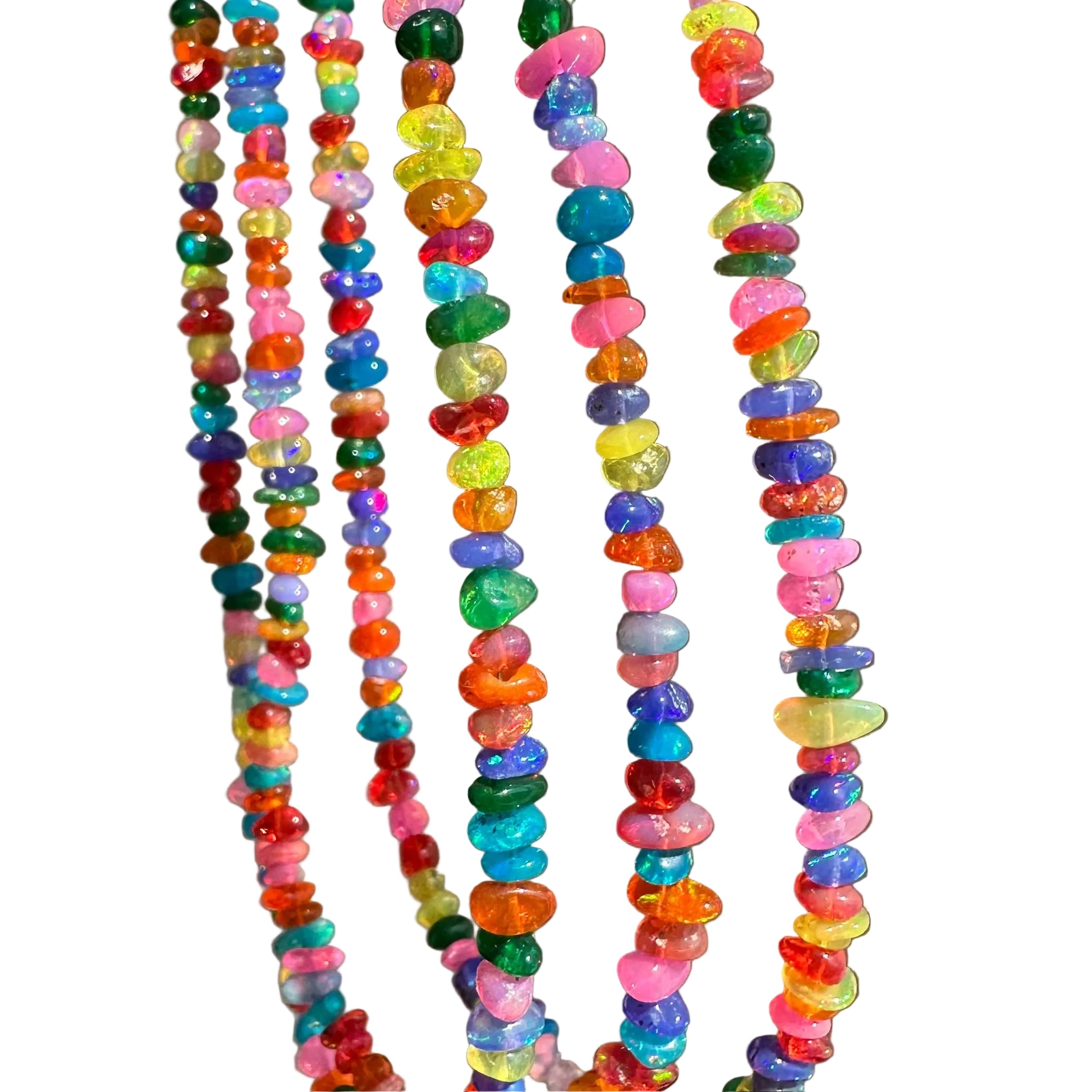 Several strands of colorful tumbled stone beads hanging vertically against a plain taupe-gray background.