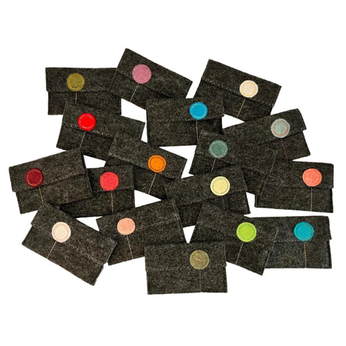 Collection of dark gray pouches with colorful dots on a white background
