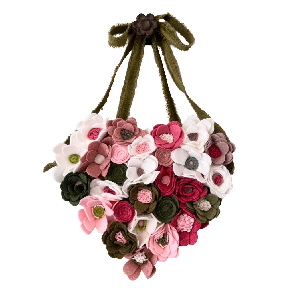Heart-shaped felt flower arrangement with a green ribbon on a white background