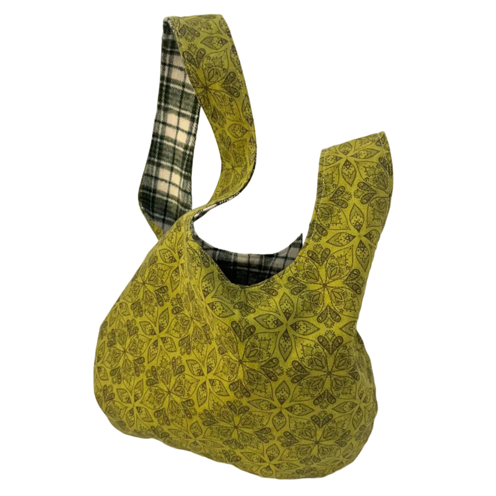 Green patterned bag with a plaid handle on a white background