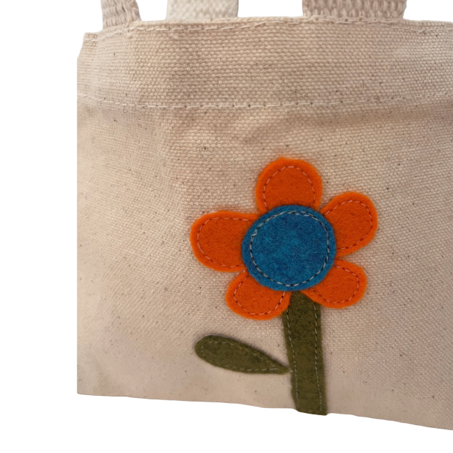 Small beige tote bag with a flower design on a white background