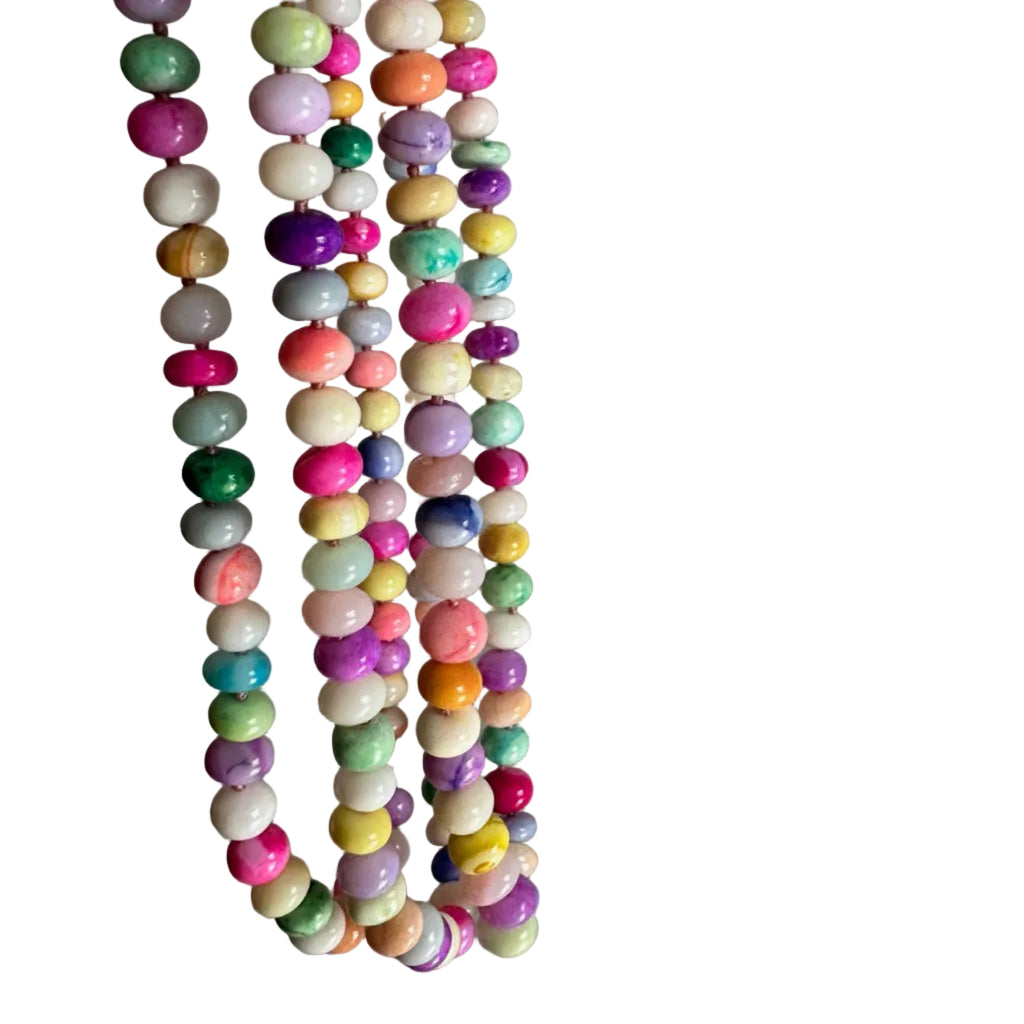 Colorful beaded necklace held against a plain background