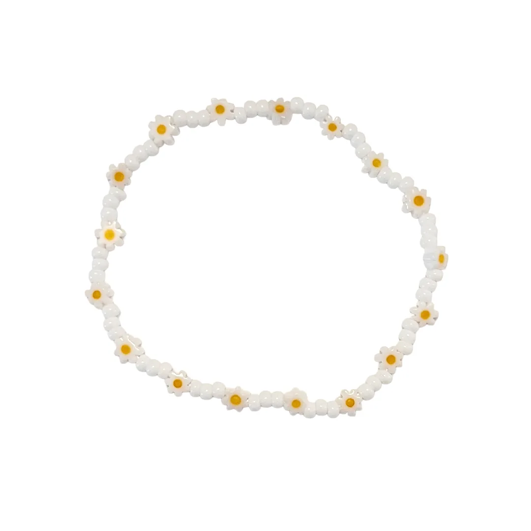 Bracelet with white beads and yellow centers on a white background