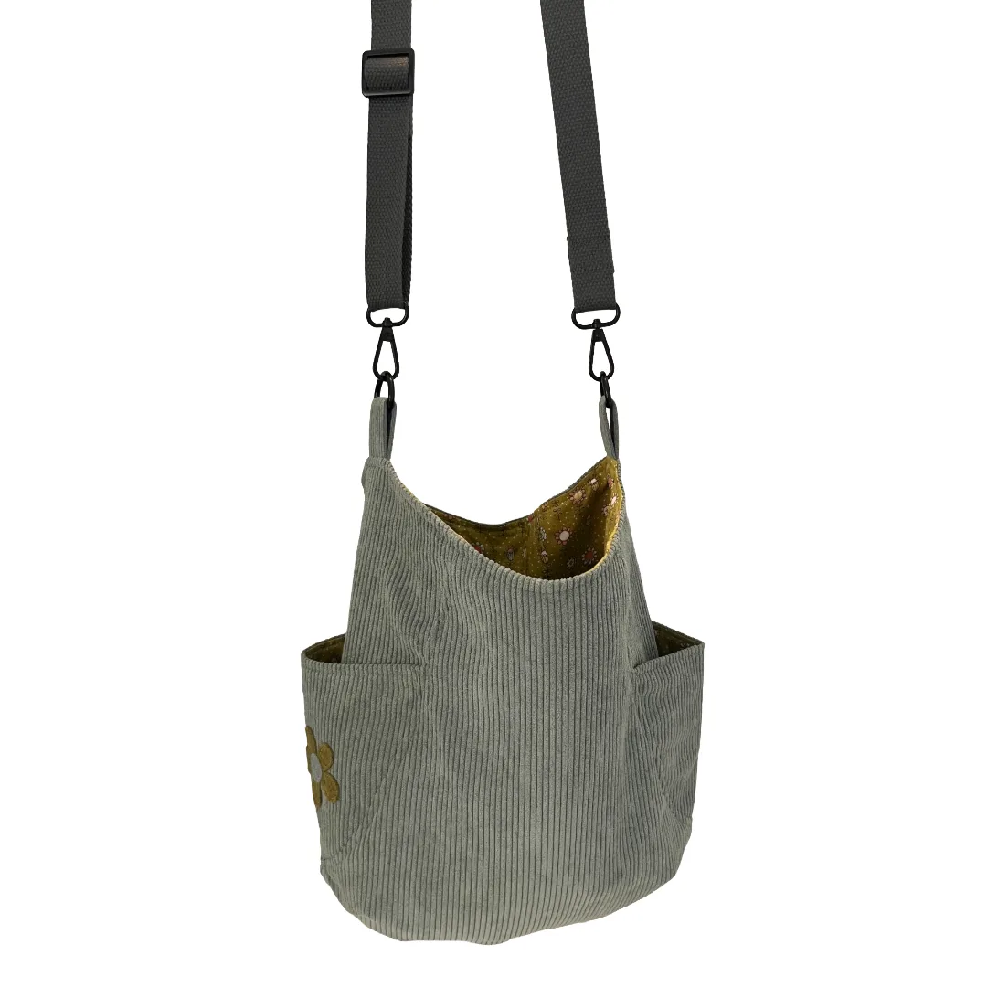 Blue corduroy bag with a strap on a white background