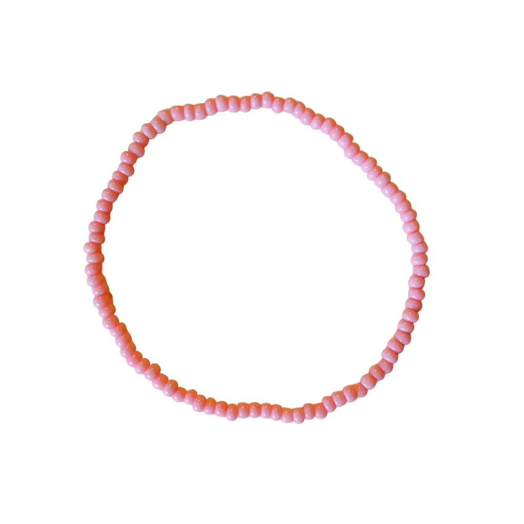 A circular beaded bracelet made of small, round beads in alternating shades of light pink, displayed on a clean white background.