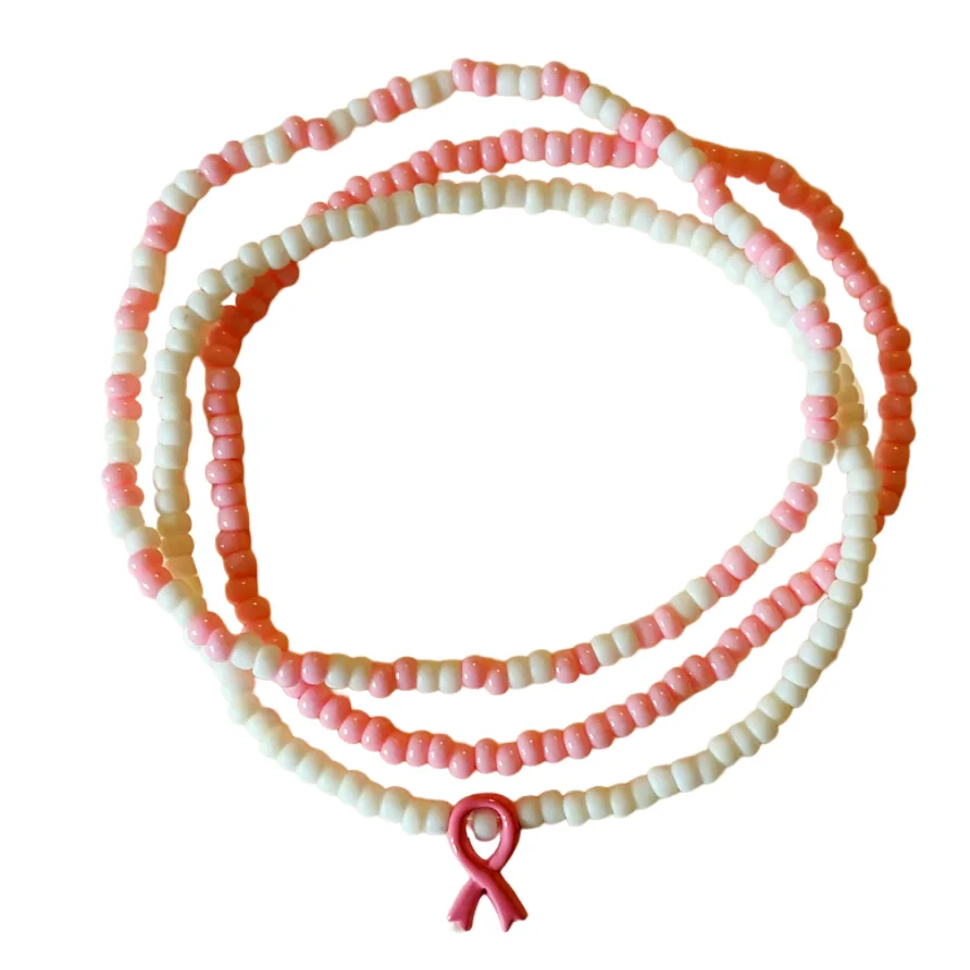 Beaded bracelets with alternating white and pink beads, featuring a pink awareness ribbon charm at the center, displayed on a clean white background.