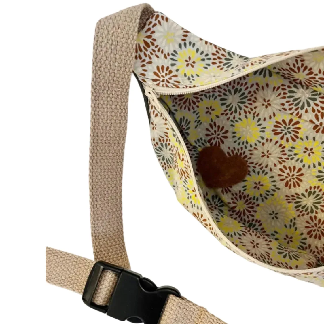 Floral-patterned sling bag with a beige strap on a white background