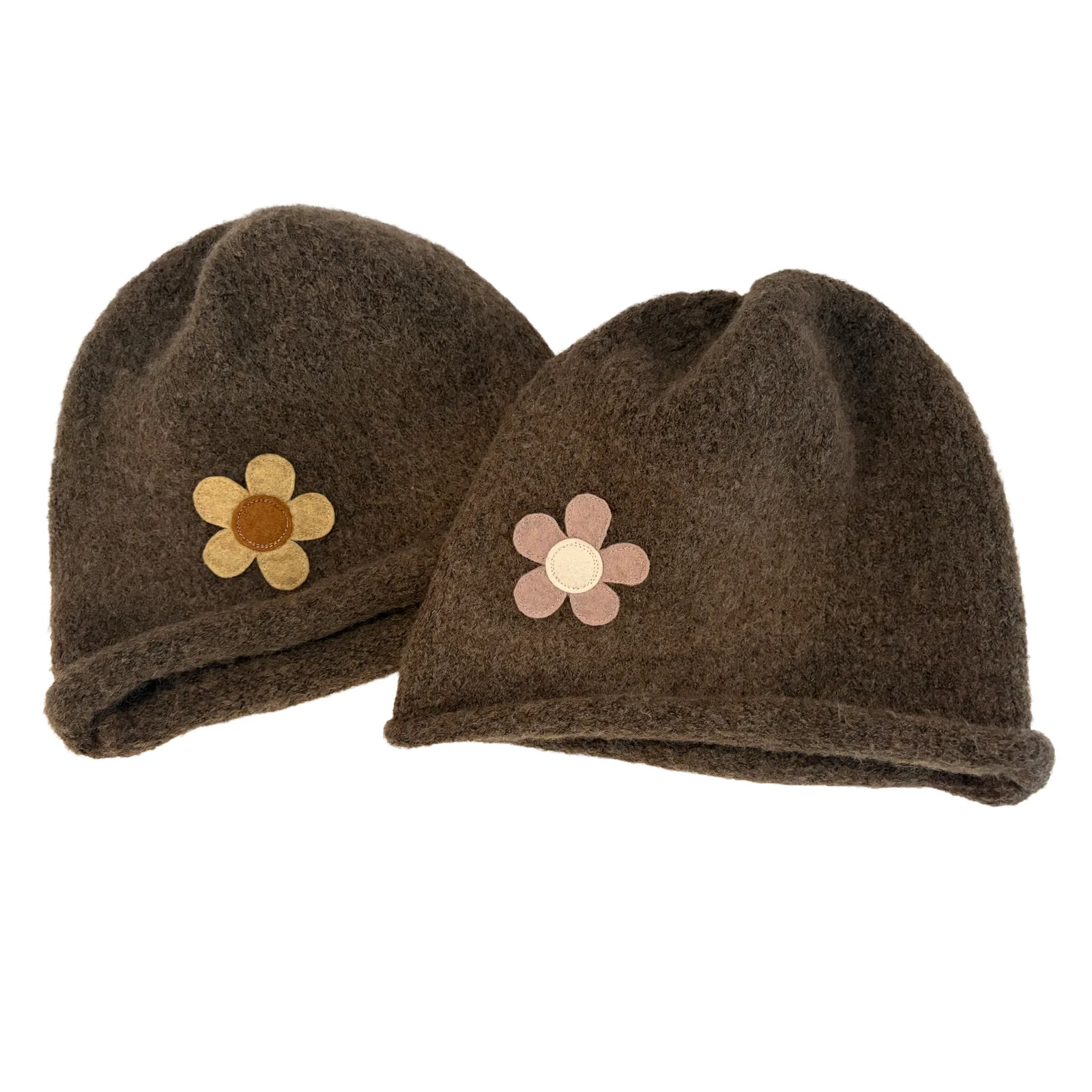 Two dark brown felted wool beanie hats with small flower appliqués, one in tan and brown and the other in pink and cream, on a plain white background.