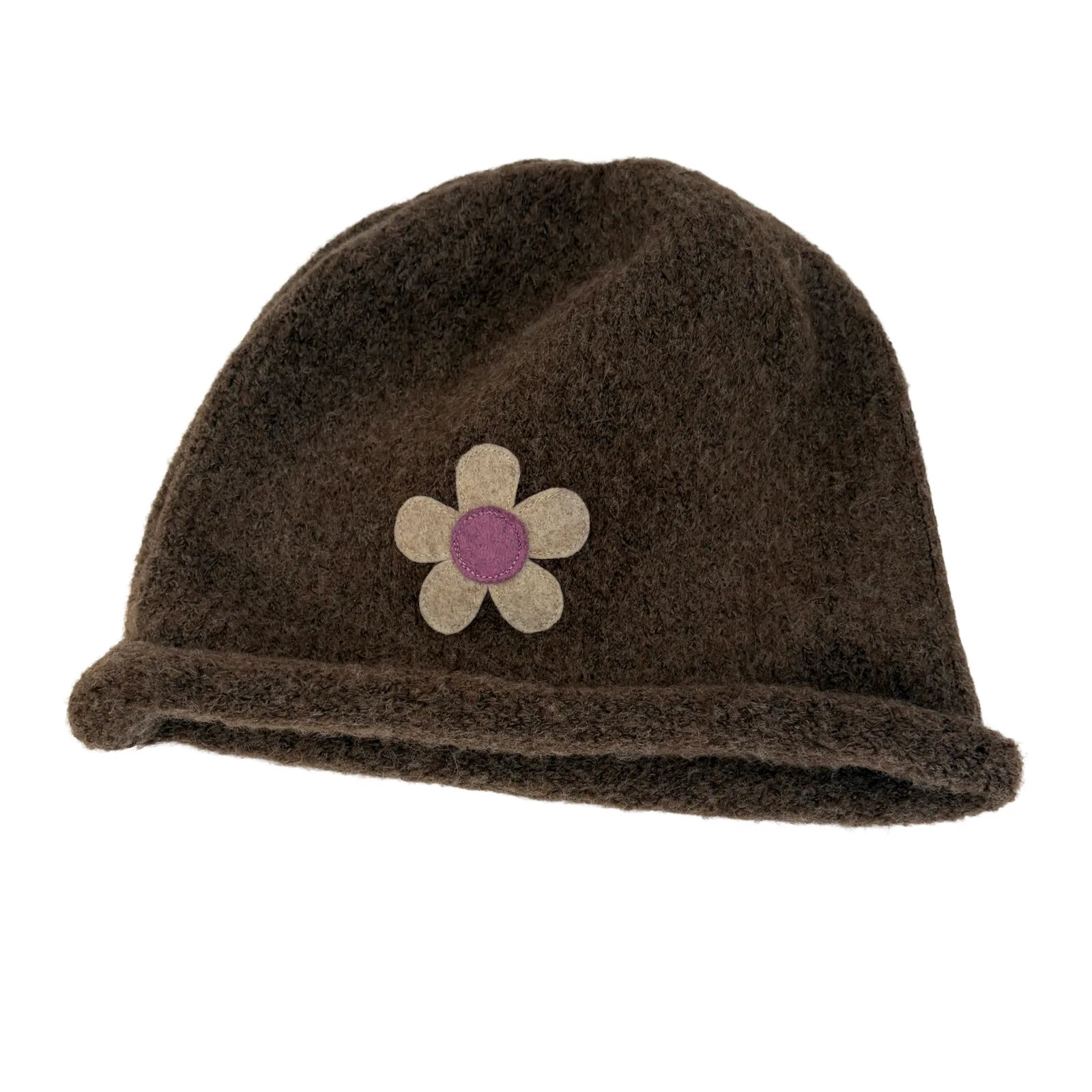 A dark brown fuzzy knit beanie hat featuring a small felt flower applique on the front with beige petals and a purple center, shown against a plain white background.