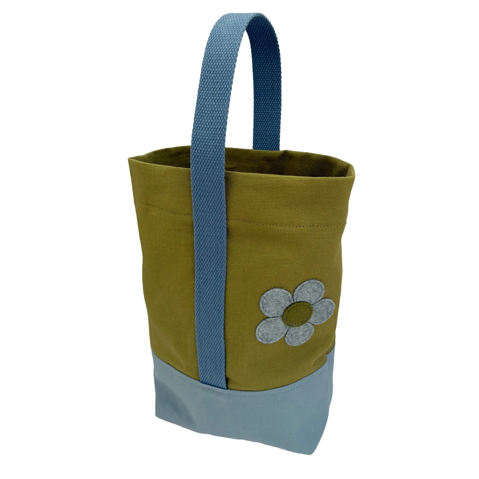 A canvas wine tote bag in olive green with a light blue base and a matching blue woven handle, featuring an applique flower on the front.