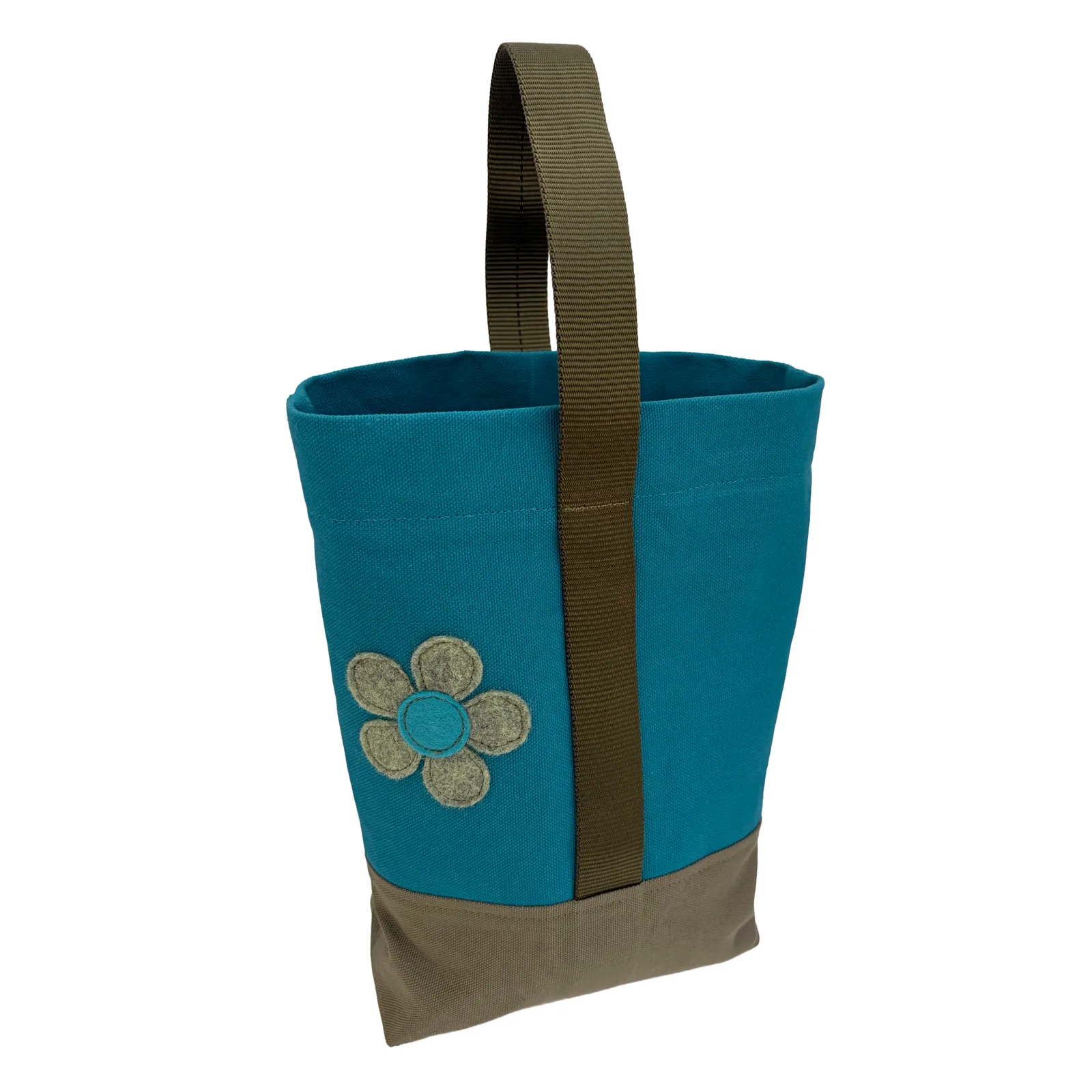 A teal canvas wine tote bag with a brown bottom panel, a brown webbing handle, and a brown fabric flower applique on the front, shown against a plain white background.