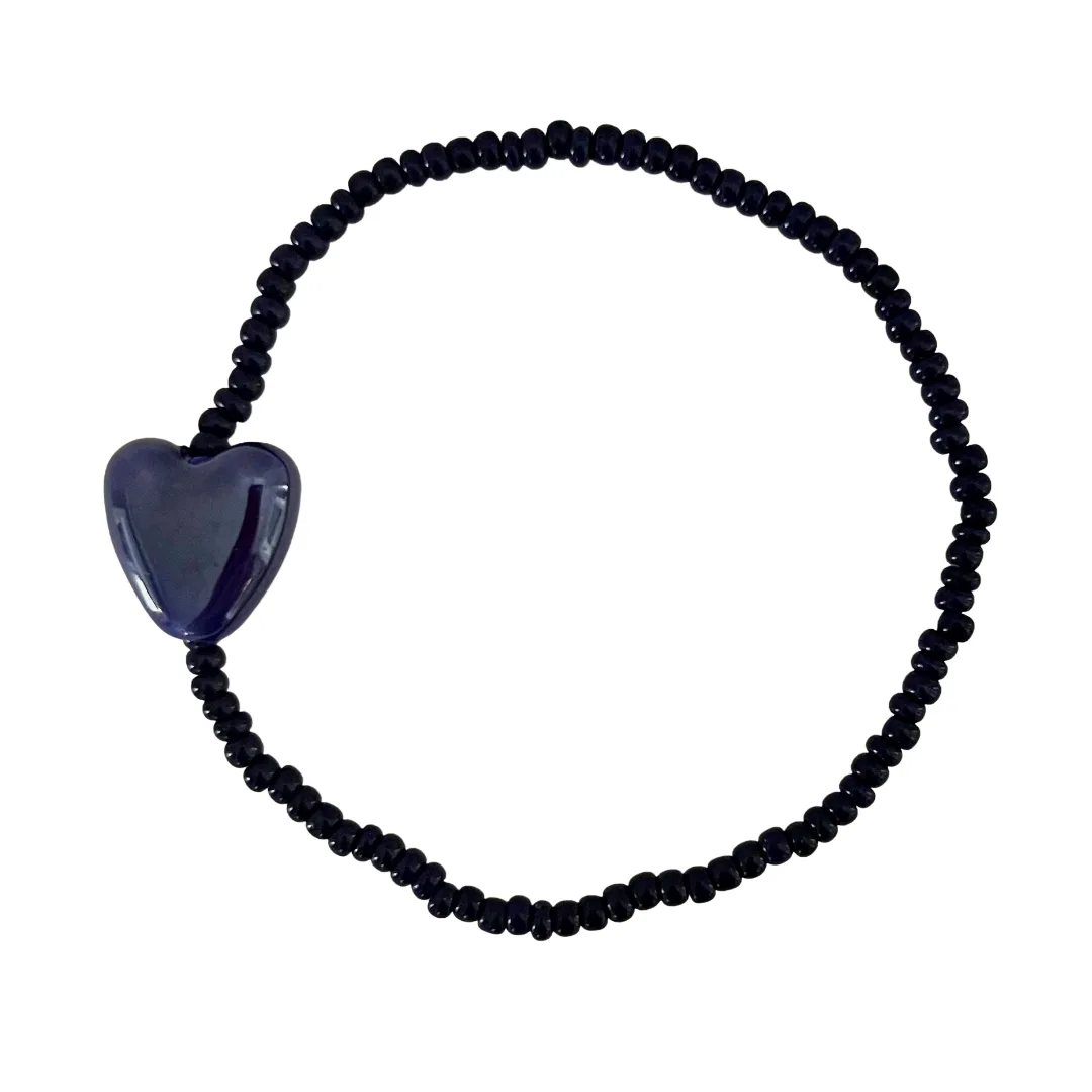 Navy beaded bracelet with a heart-shaped charm on a white background