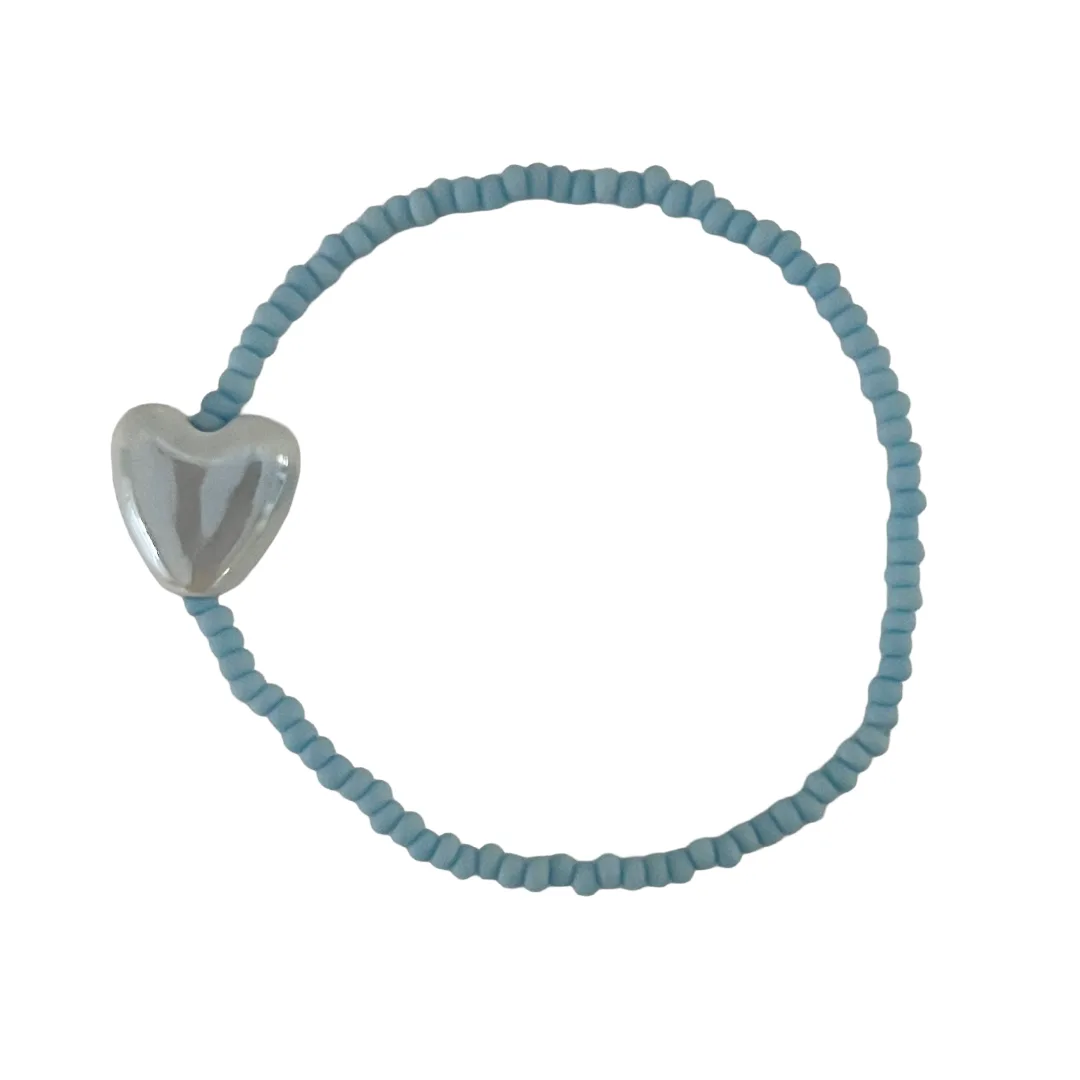 Blue beaded bracelet with a heart-shaped charm on a white background