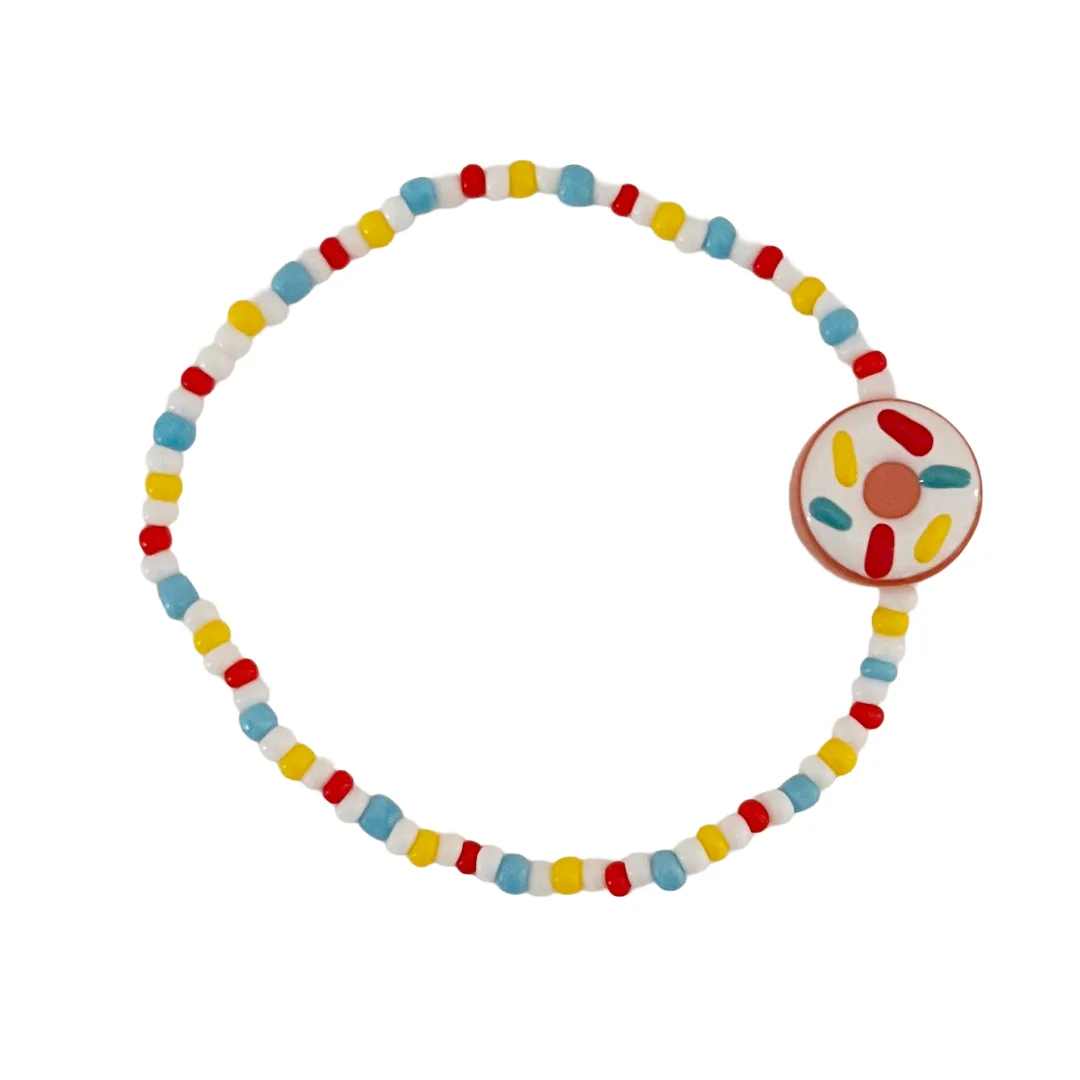 Colorful beaded bracelet with a sprinkle donut bead on a white background