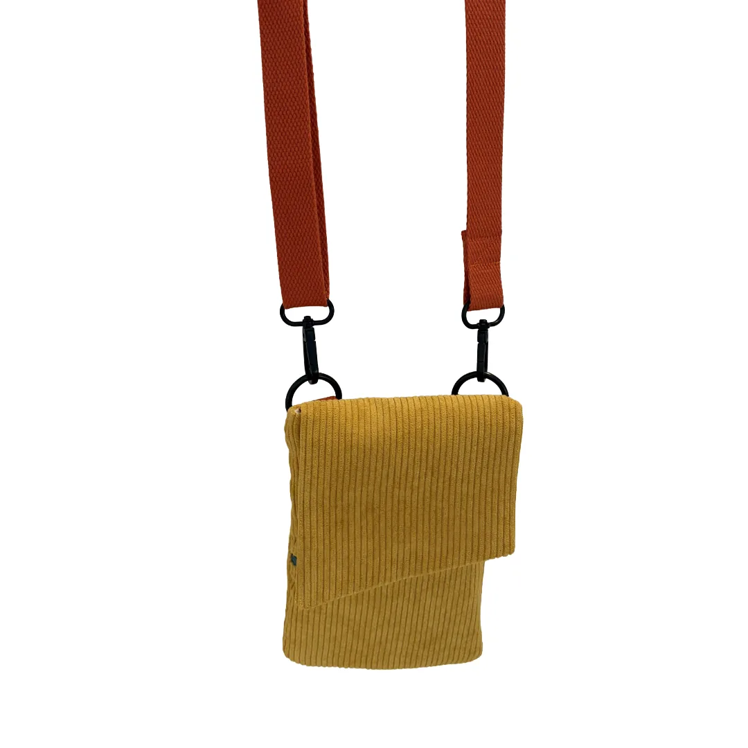 A mustard yellow corduroy crossbody pouch with a rust-orange adjustable strap and black metal hardware, shown against a plain white background.