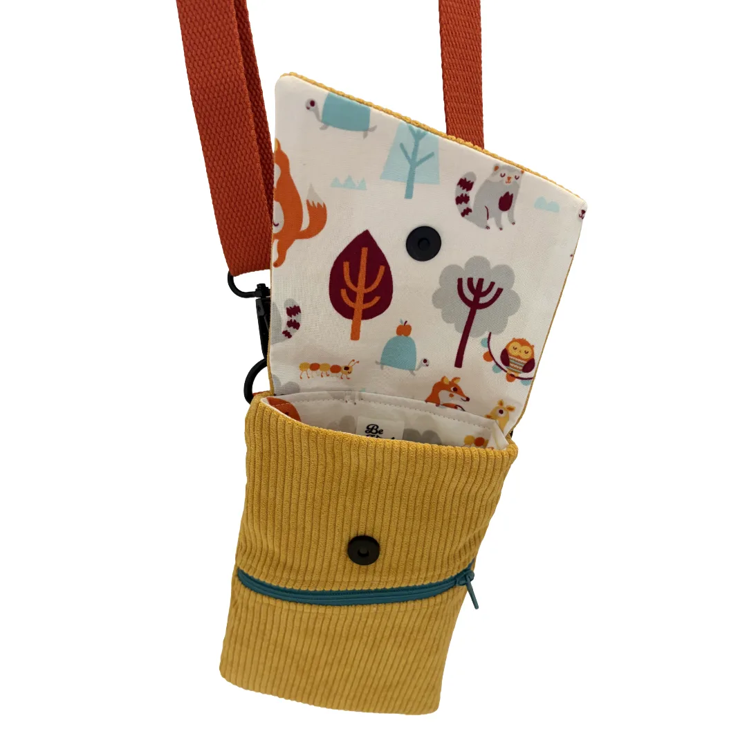 A small fabric pouch or phone case with a mustard yellow corduroy lower section, a teal zipper, and a multicolor woodland print lining, shown on a plain white background.