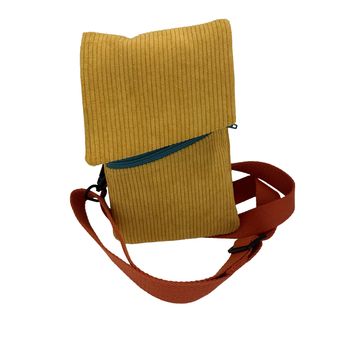 A mustard yellow corduroy crossbody pouch with a teal zipper and a rust-colored adjustable strap, shown on a plain white background.