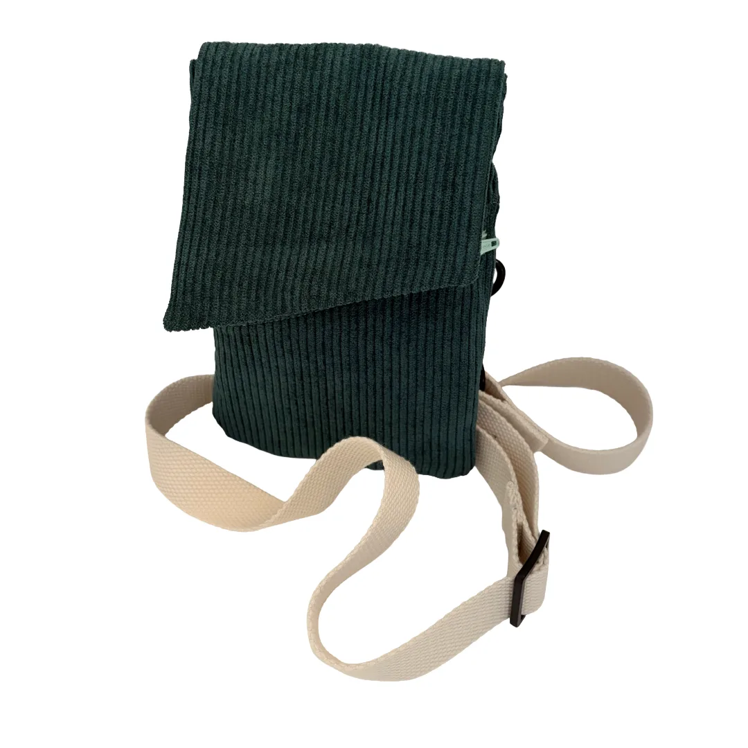 A teal green corduroy crossbody bag with a beige adjustable fabric strap, shown on a plain white background.