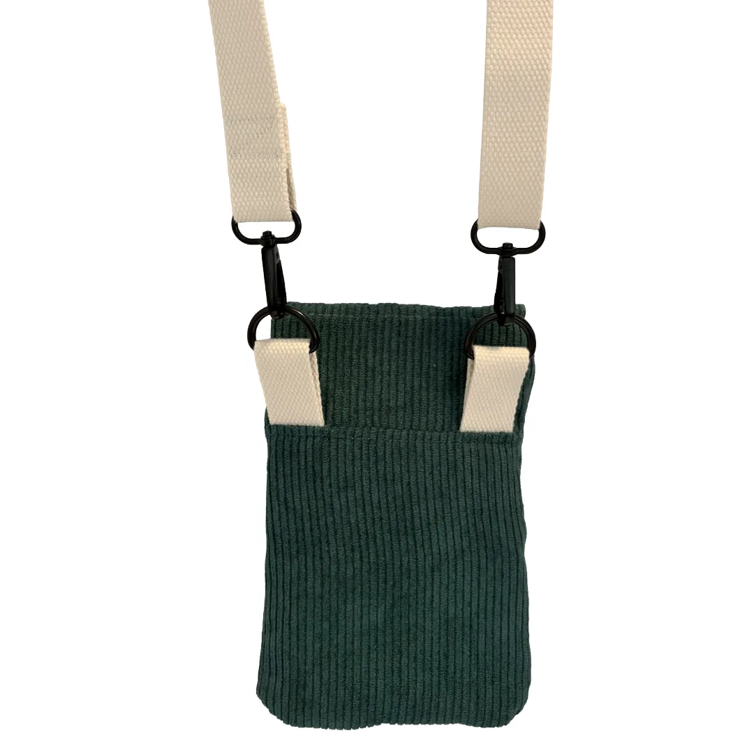A teal green corduroy crossbody bag with an adjustable cream-colored webbed strap and black metal hardware, shown against a plain white background.