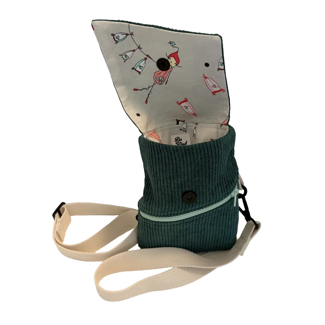 A small corduroy shoulder bag in dark teal green with a cream canvas strap and a flap insert featuring a red and white fisherman pattern, shown on a plain white background.