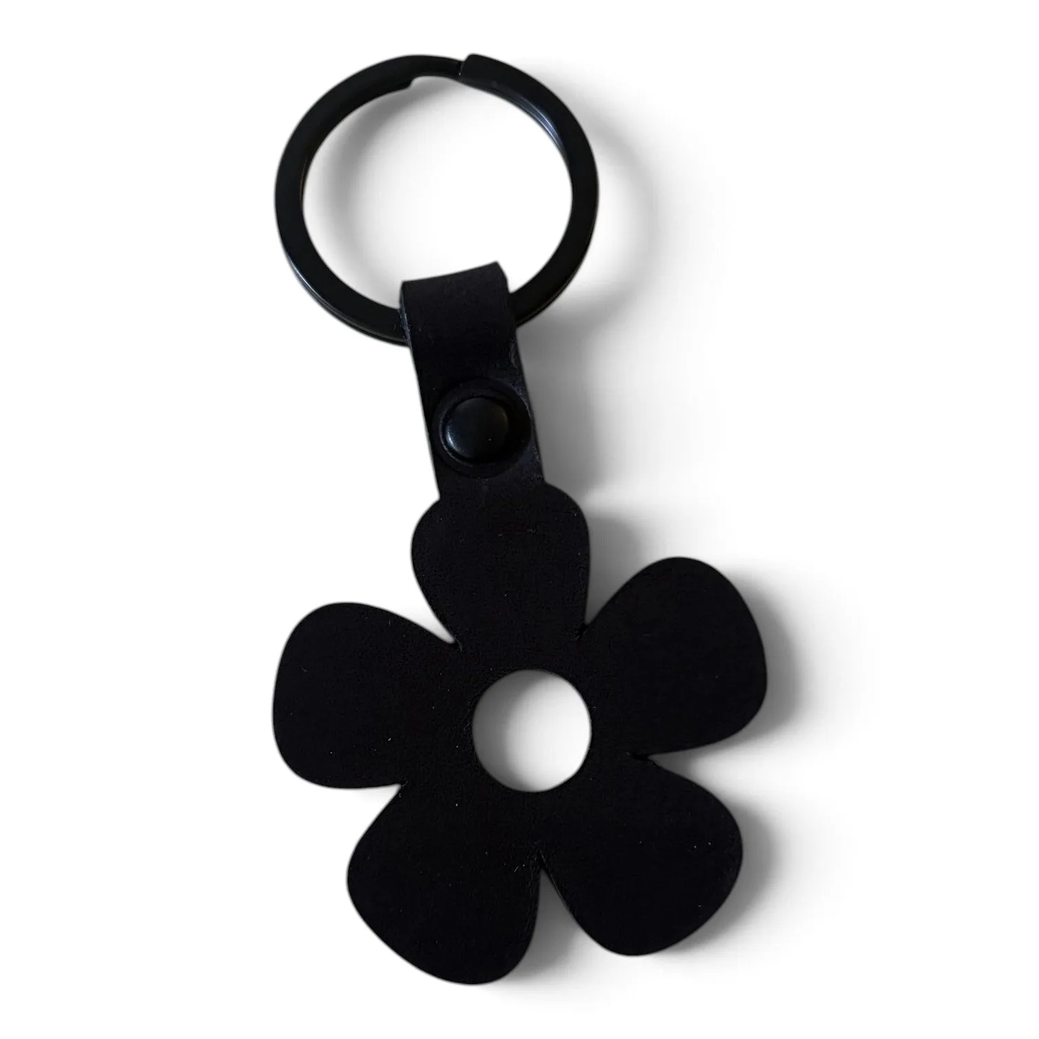 A black metal flower-shaped keychain with a circular split ring and a small black button clasp, shown on a plain white background.