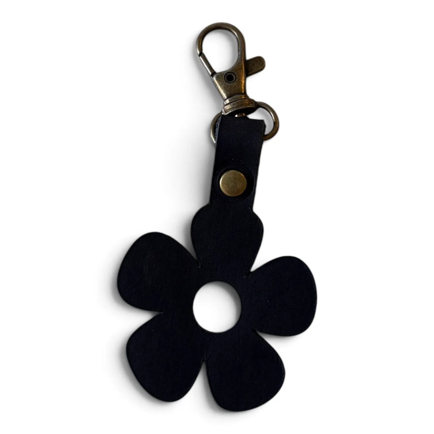 A black five-petal flower-shaped keychain or bag charm with a brass-toned lobster clasp and a small brass rivet, shown on a plain white background.