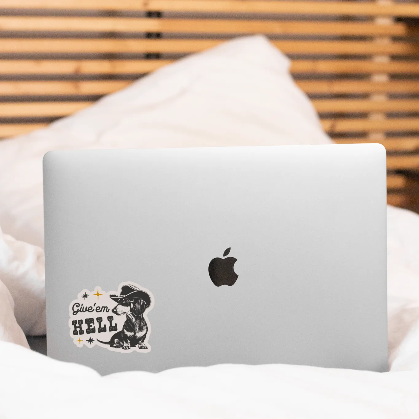 Silver laptop with a sticker on a white surface with a wooden background