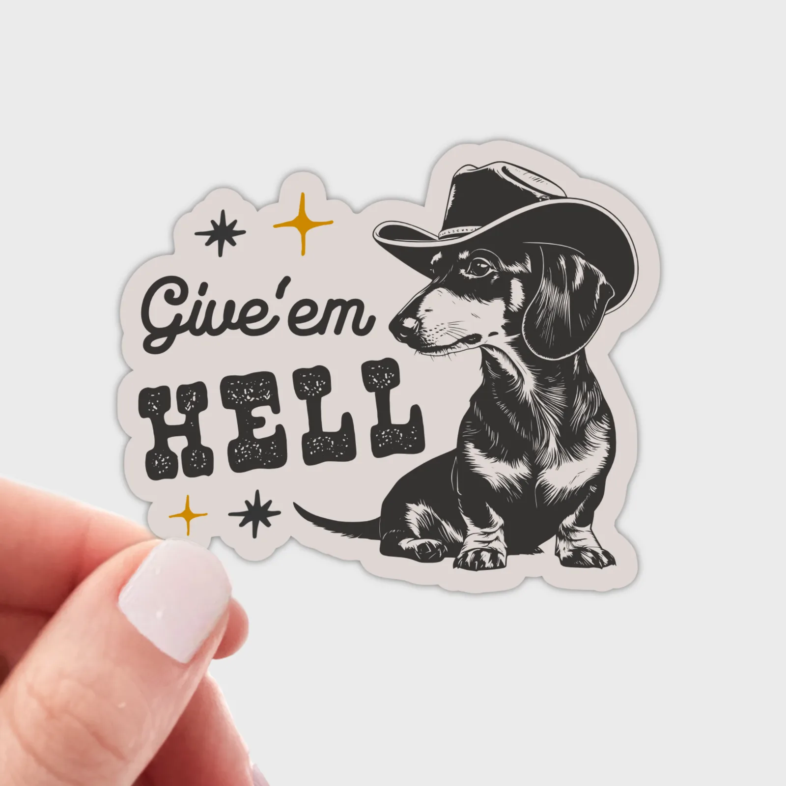 Sticker with a dachshund wearing a cowboy hat and 'Give'em Hell' text on a white background.