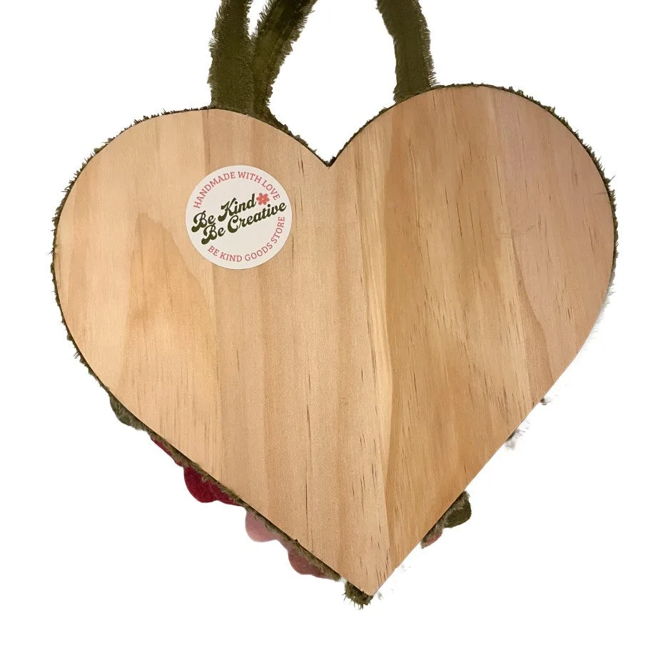 Heart-shaped hanging wooden board with a brand label on a white background