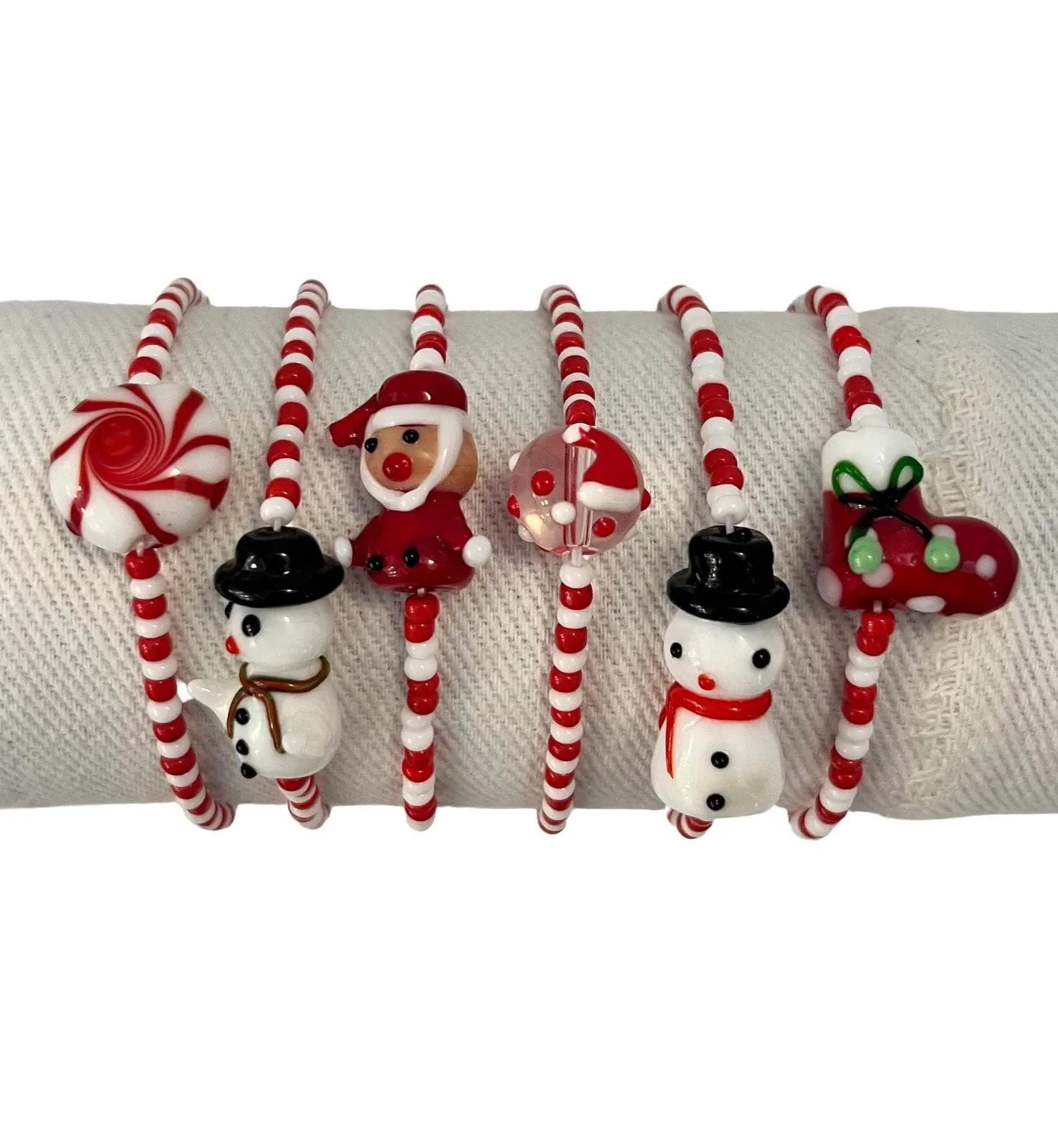 Set of Christmas-themed candy cane and snowman bracelets on a white background