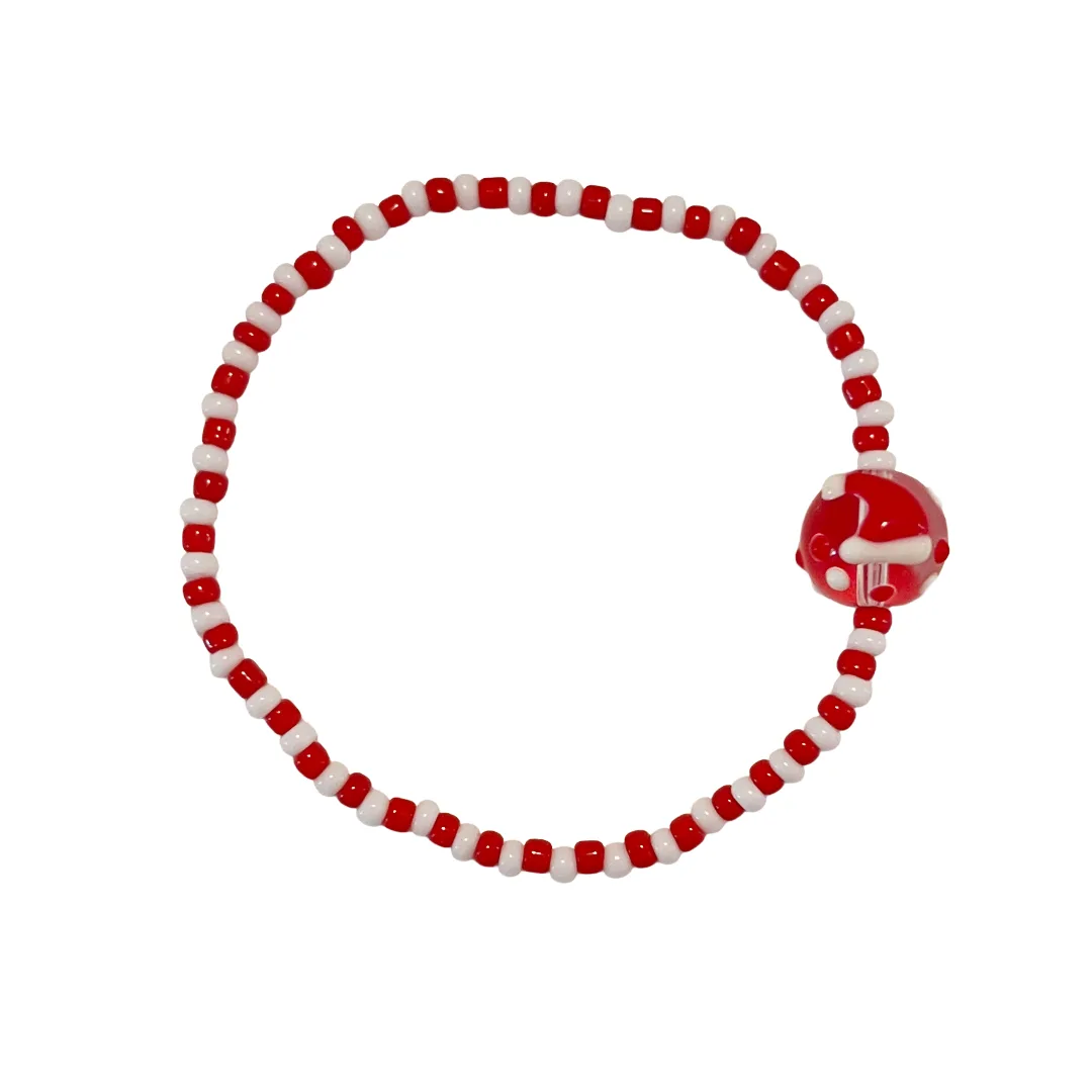 Red and white beaded bracelet with a red charm on a white background
