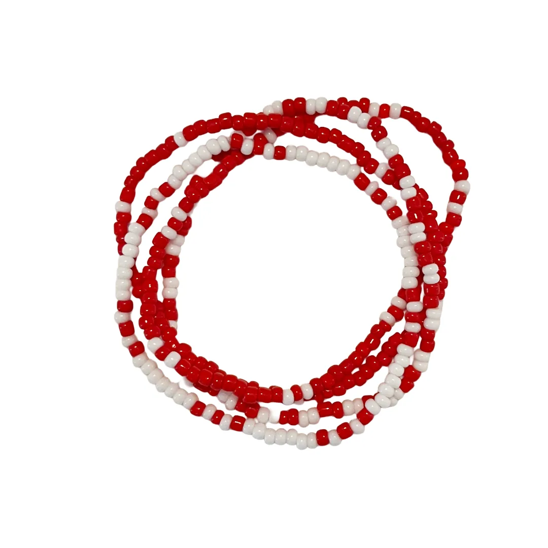 Red and white beaded bracelets stacked on a white background