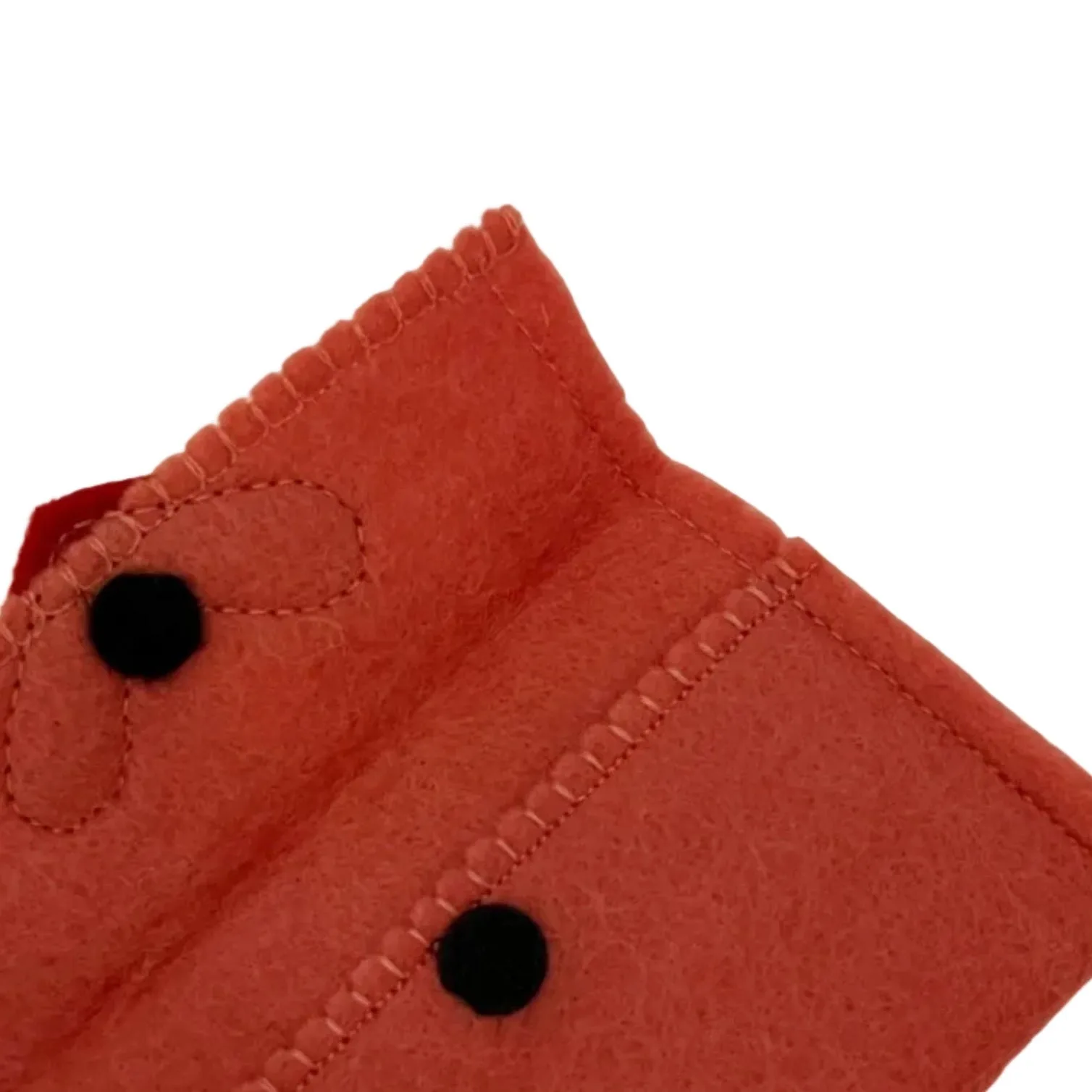 Close-up of a red fabric with black buttons on a white background