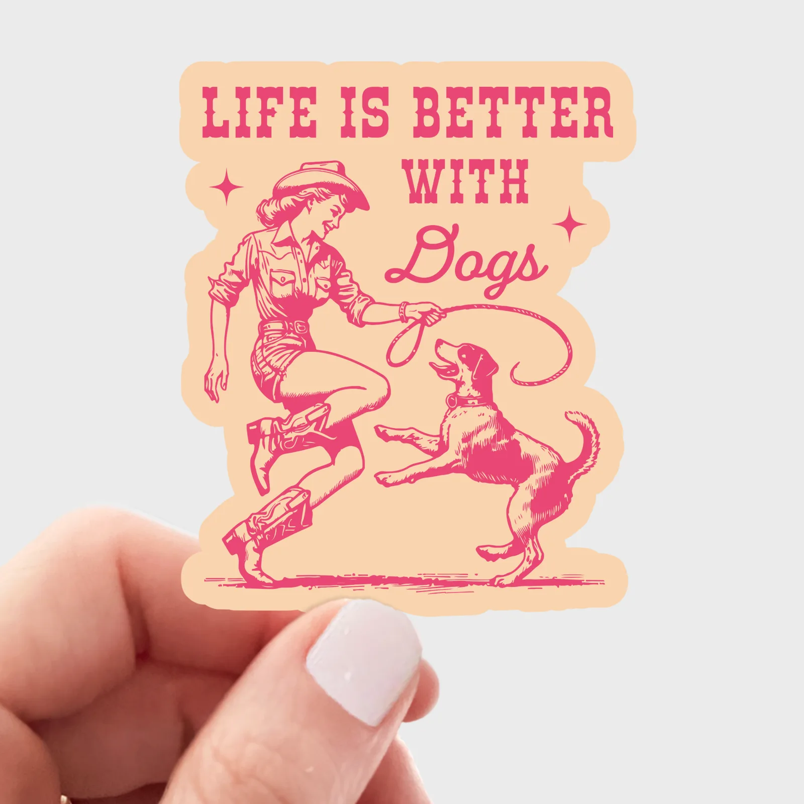 Sticker with a woman and dog illustration and 'Life is Better with Dogs' text held by a hand.