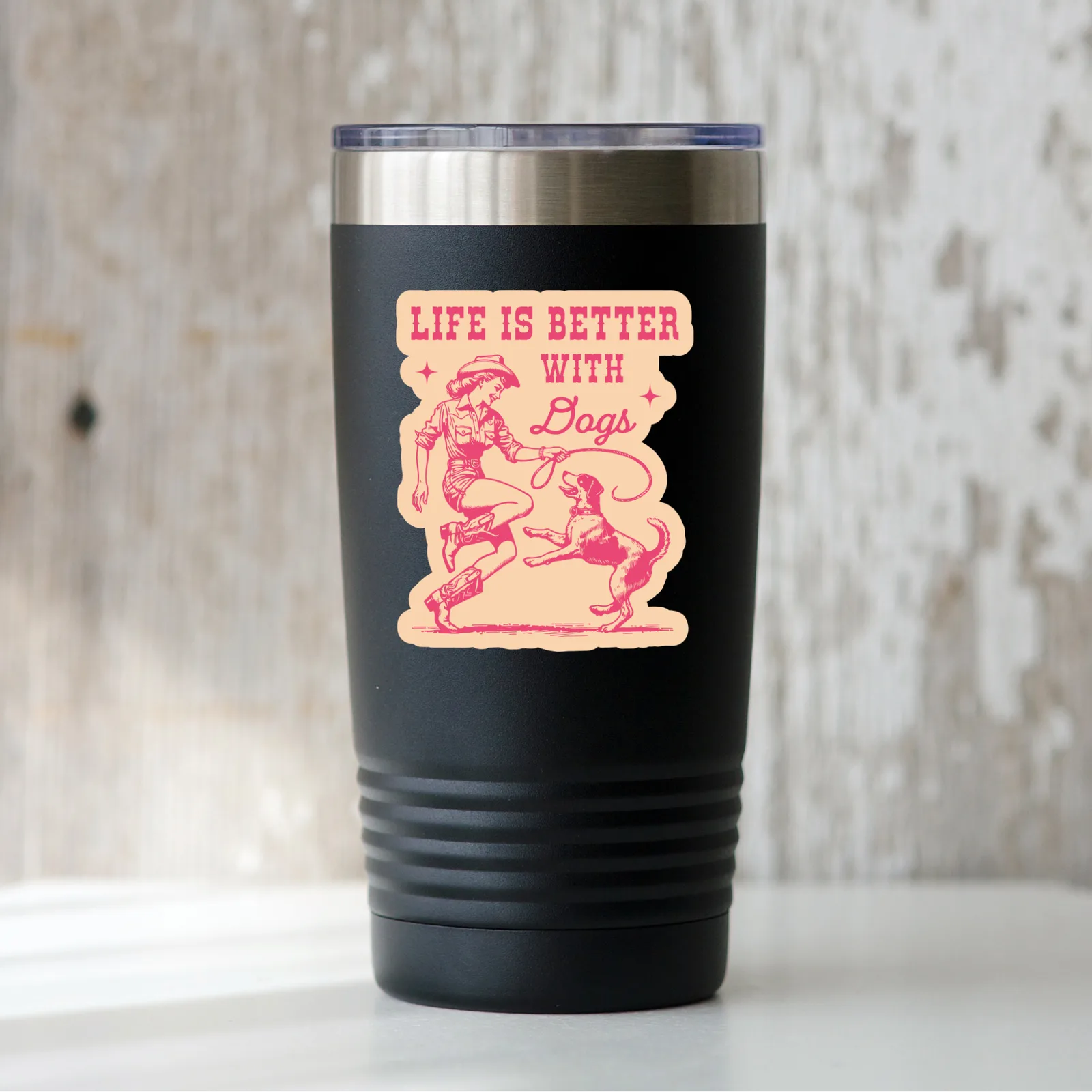 Black tumbler with pink graphic and text 'Life is Better with Bags' on a wooden surface.