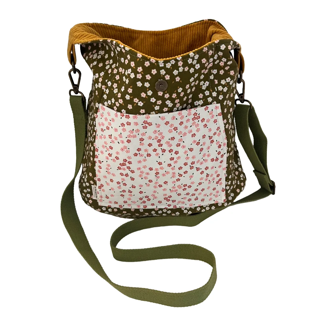 Floral-patterned bag with a green strap on a white background