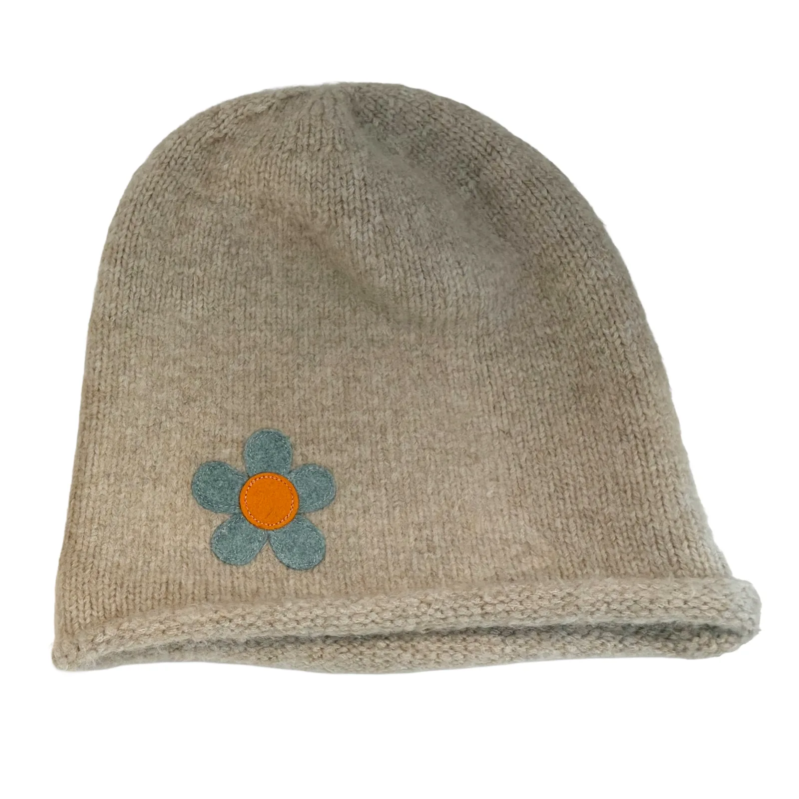 A beige knit beanie hat featuring a small embroidered flower with blue petals and an orange center on the front left side, shown against a plain white background.