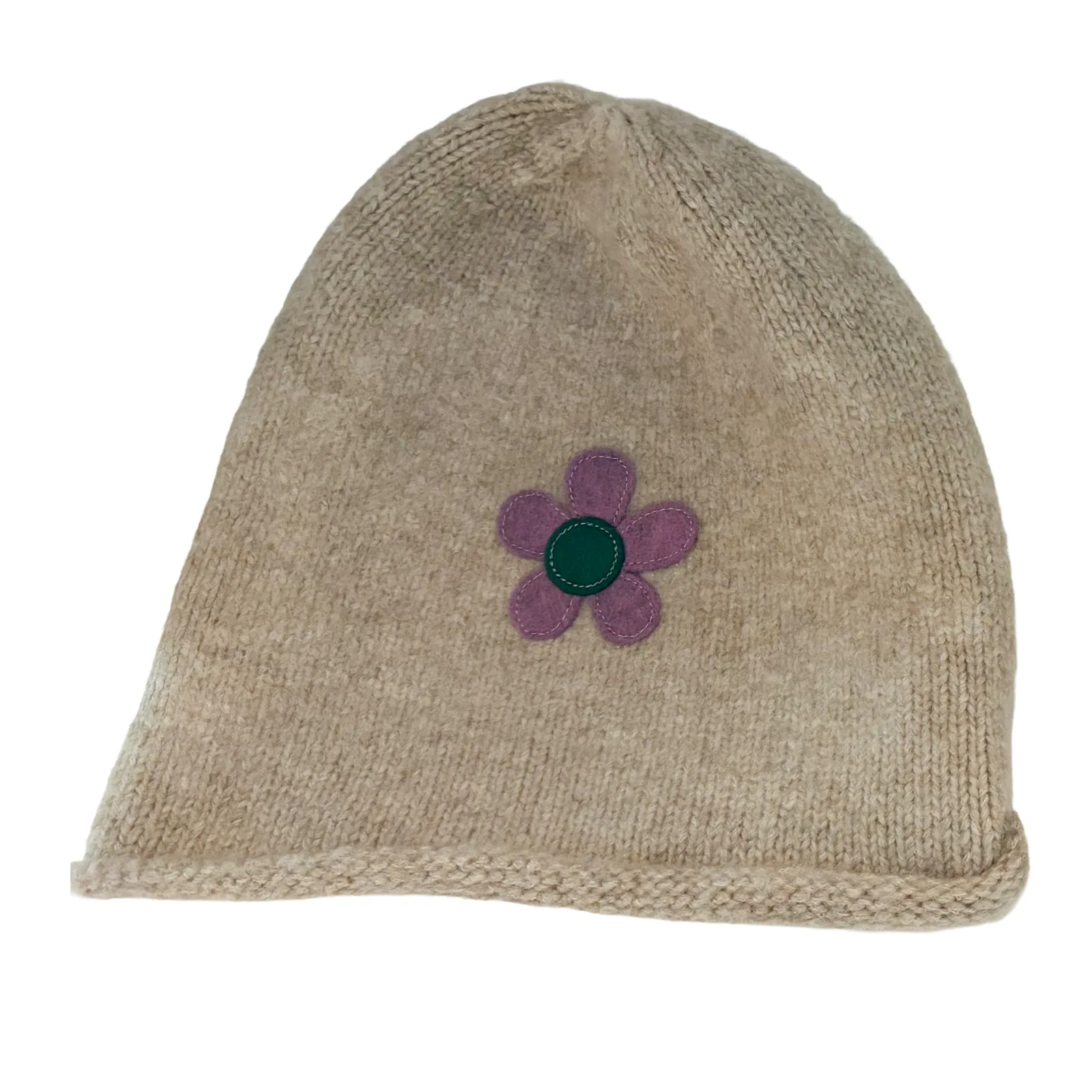 A beige knit beanie hat featuring a small purple flower applique with a green center on the front, set against a plain white background.