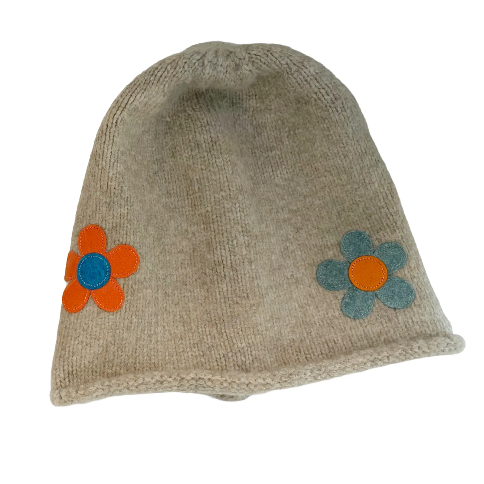 A beige knit beanie hat featuring two small felt flower appliqués on the sides, one orange with a blue center and one blue with an orange center, shown against a plain white background.