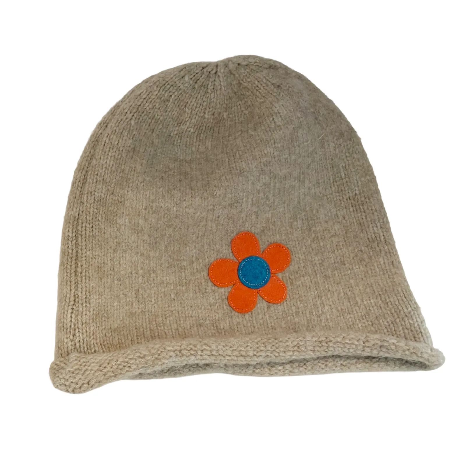 A beige knit beanie hat featuring an embroidered orange flower with a blue center on the front, set against a plain white background.