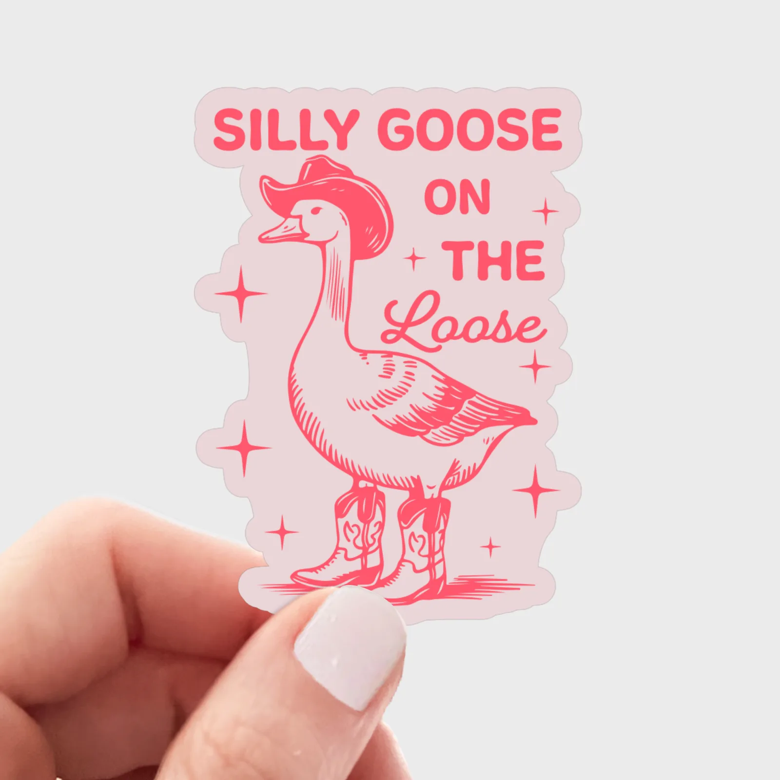 Sticker with a goose wearing cowboy boots and text 'Silly Goose on the Loose' held by a hand.