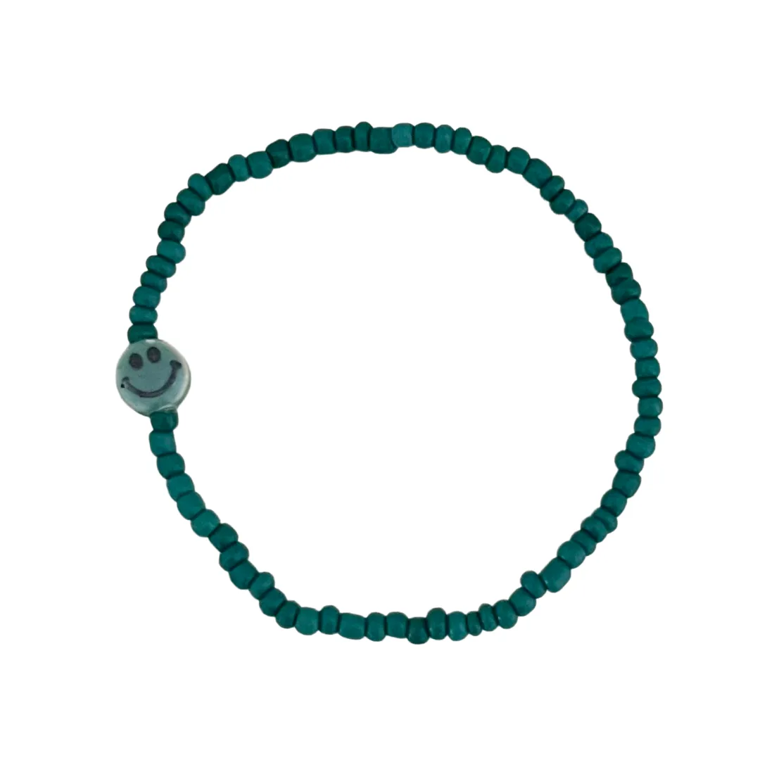 Teal beaded bracelet with a smiley face charm on a white background