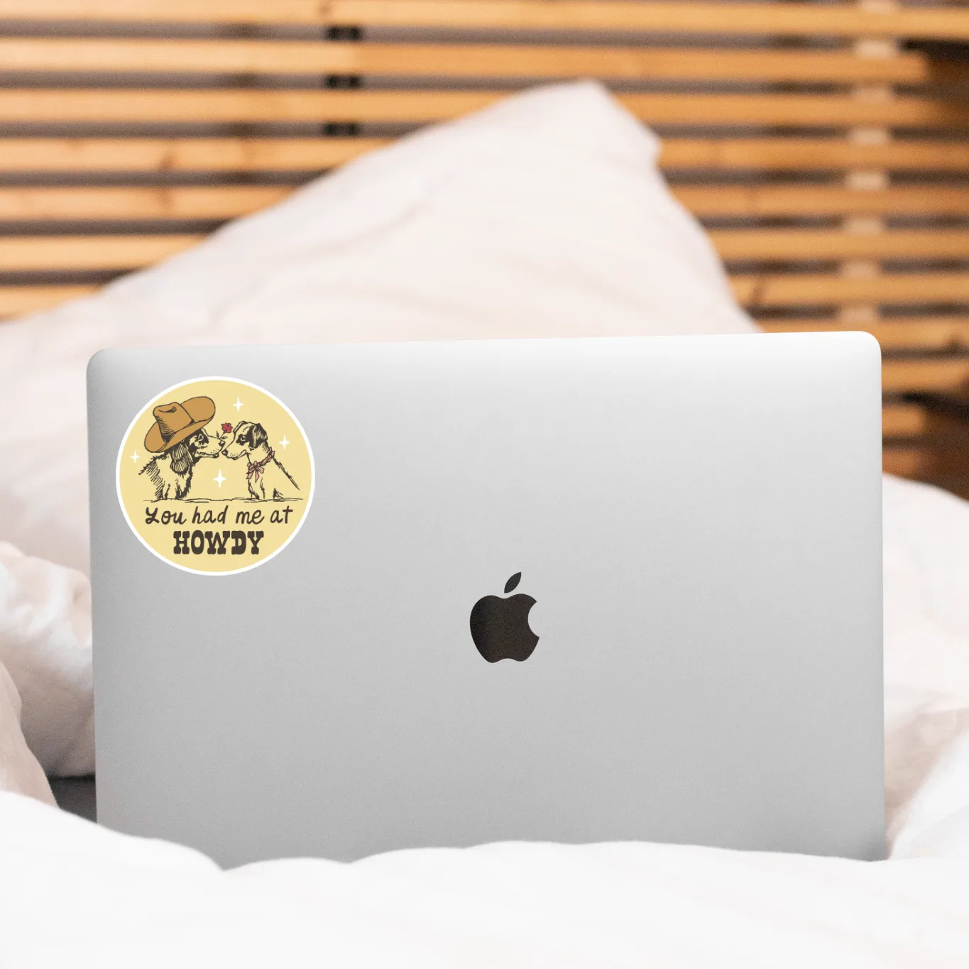 Laptop with a colorful sticker on a bed